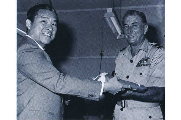 Air Vice-Marshal Susans receiving a Singapore flag for Headquarters IADS