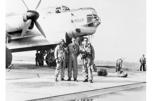 Group portrait of three men standing in front of an Avro Lincoln, A73-2 'Nyhuan' also known as 'Pathfinder', a long range navigation trainer and survey aircraft.