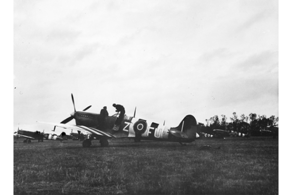 No 453 Squadron Spitfires, featuring black and white invasion stripes on their wings, at an beachhead airstrip in Normandy, June 1944